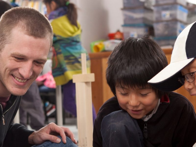 Student teacher playing a game with young students.