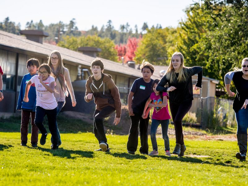 Student teachers running with young students.