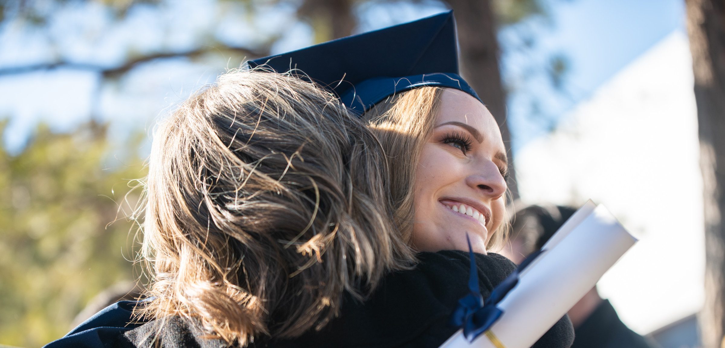 N A U student hugging someone after commencement.