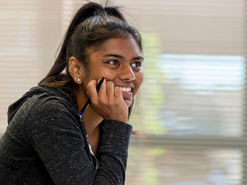 Student sitting in classroom listening to professor teach.