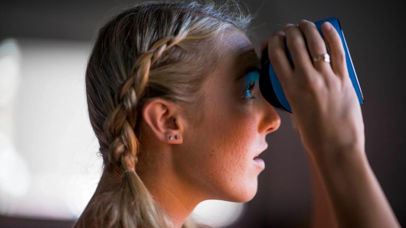 N A U student looking through a pair of binoculars.