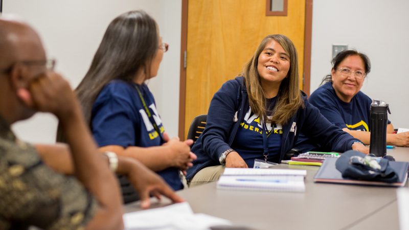 N A U students talking together in a classroom.