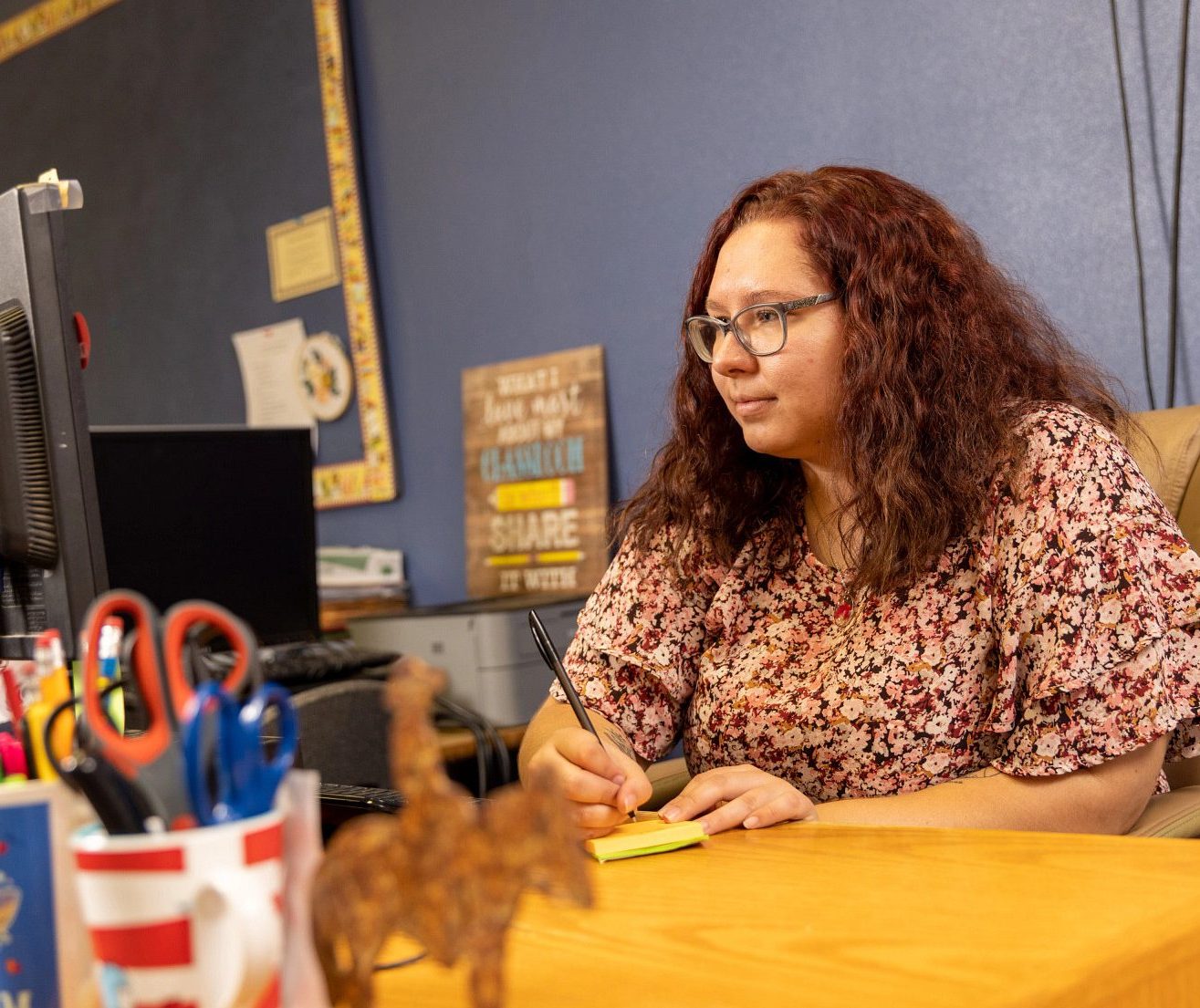 Student teacher writing on a stack of post-it notes.