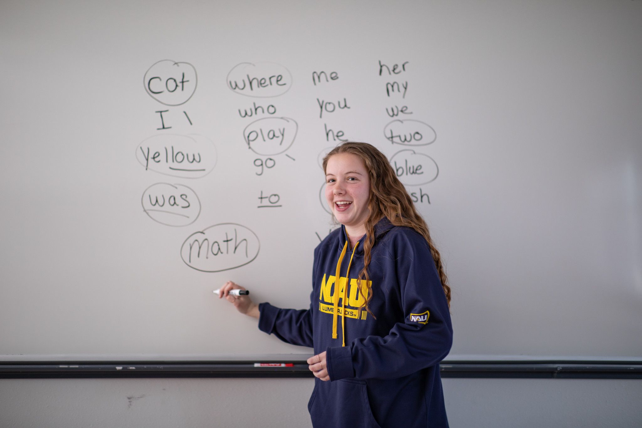 N A U student teacher writes on white board.