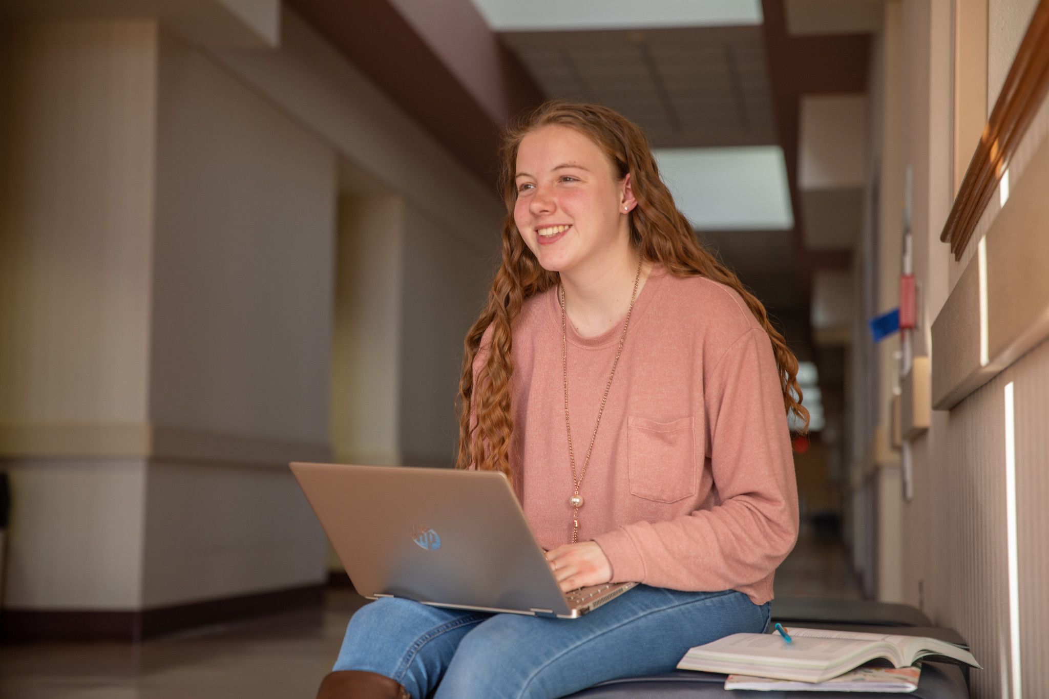 N A U student smiles while working on their laptop.