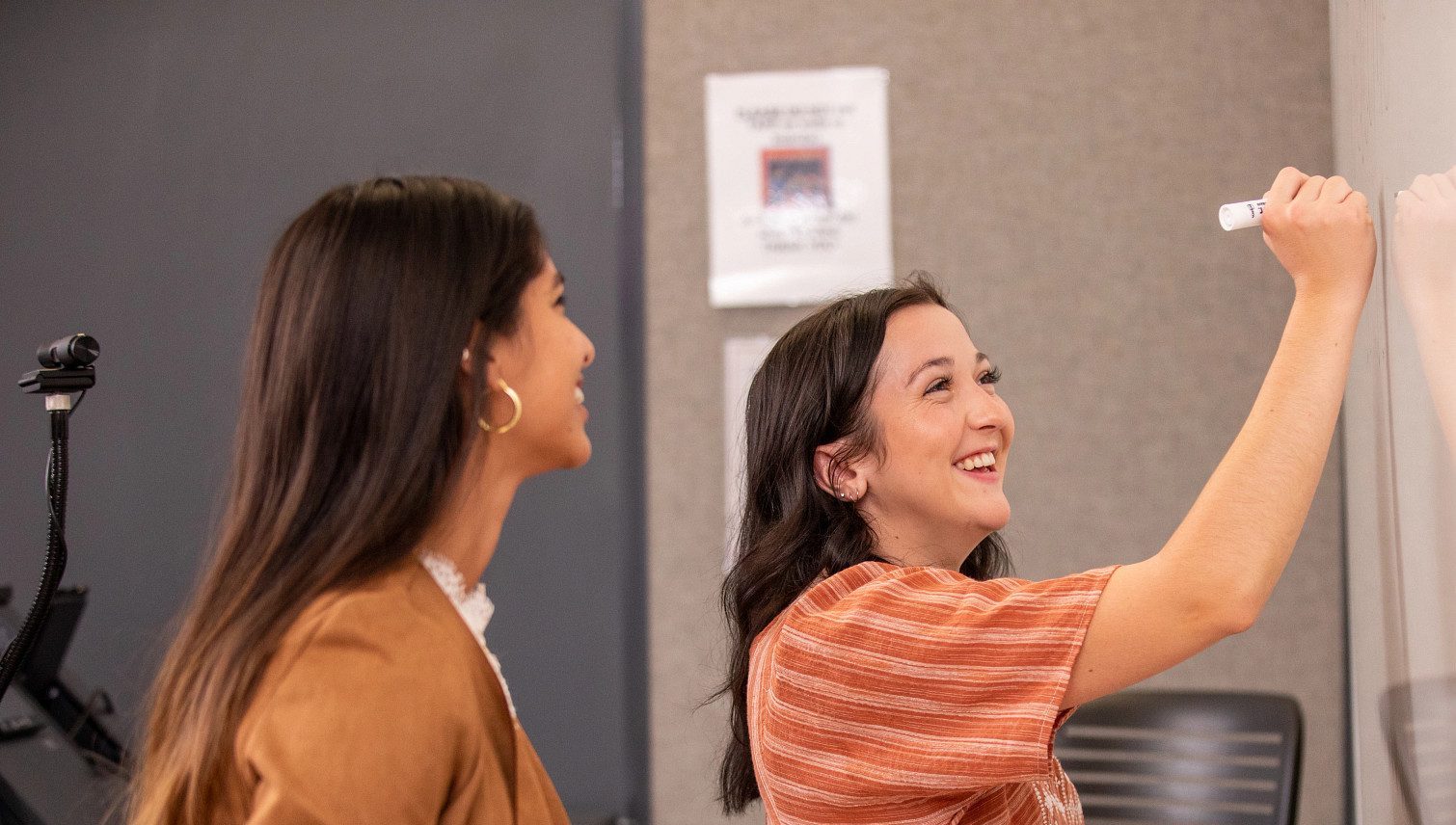 N A U students writing on a white board.