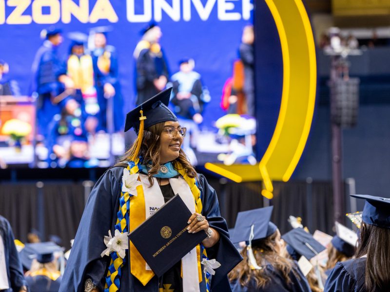 N A U student at graduation with their diploma.