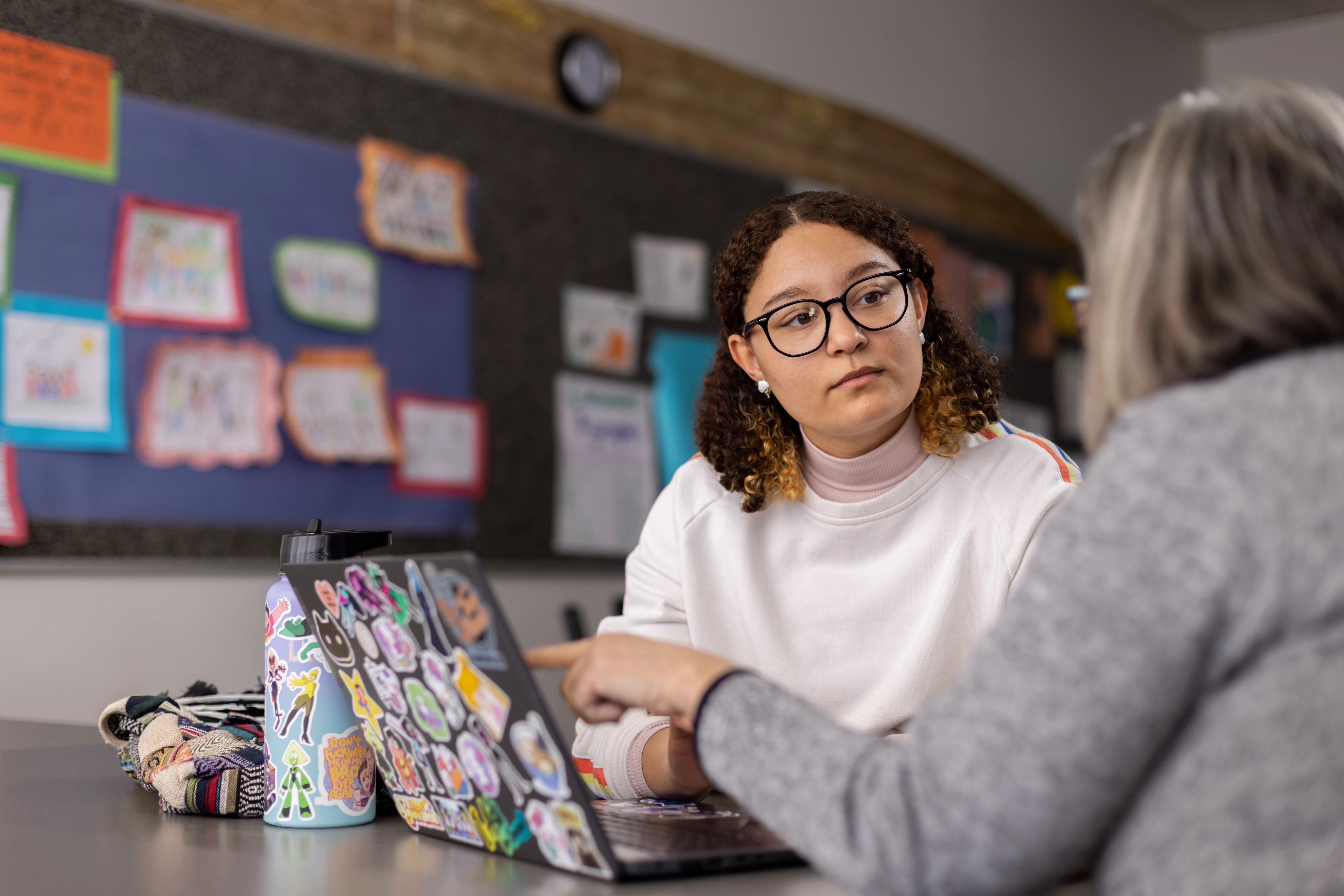 N A U professor and student sitting at a table talking to each other.