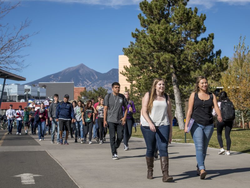 N A U students walking outside on campus.