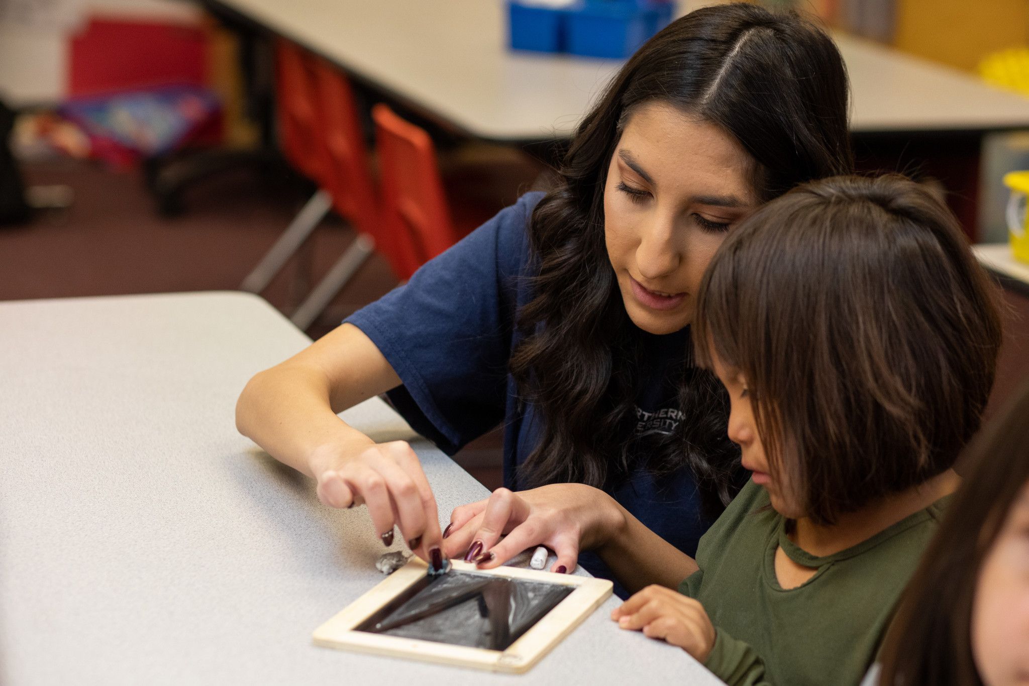 N A U student teacher helps child with project.