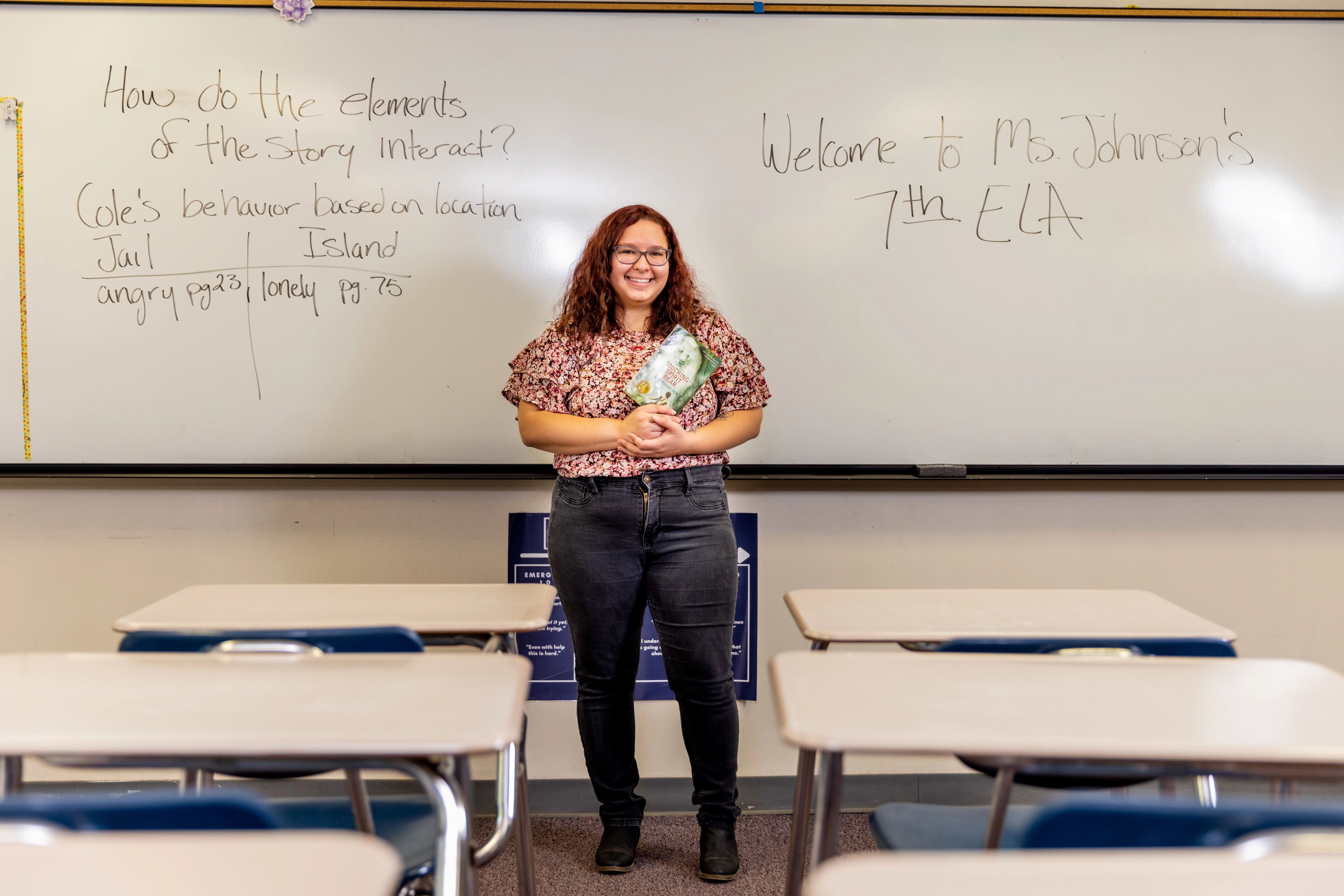 N A U student teacher standing in front of classroom with a book in hand.