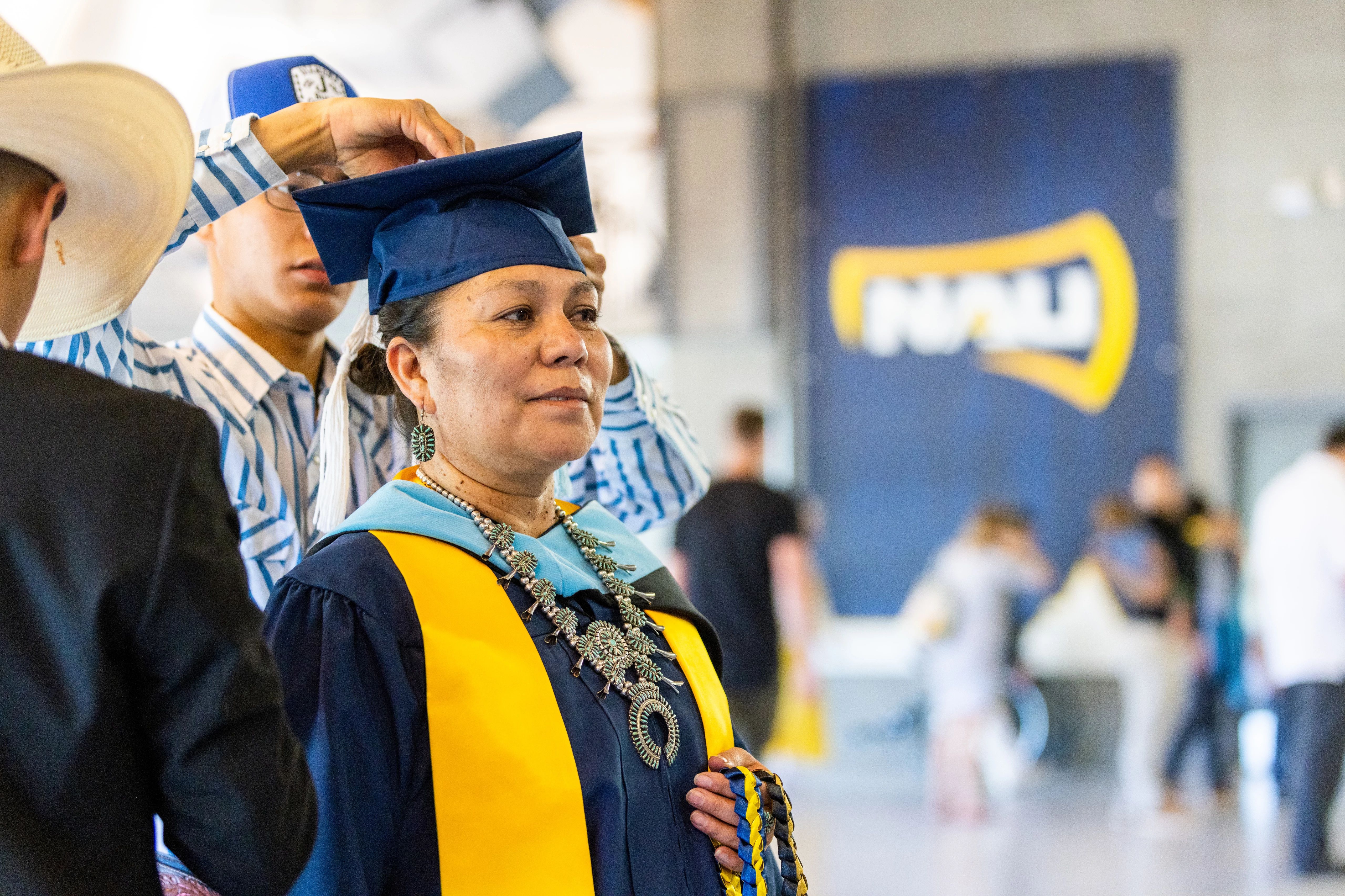 N A U student dressed in her cap and gown at commencement.