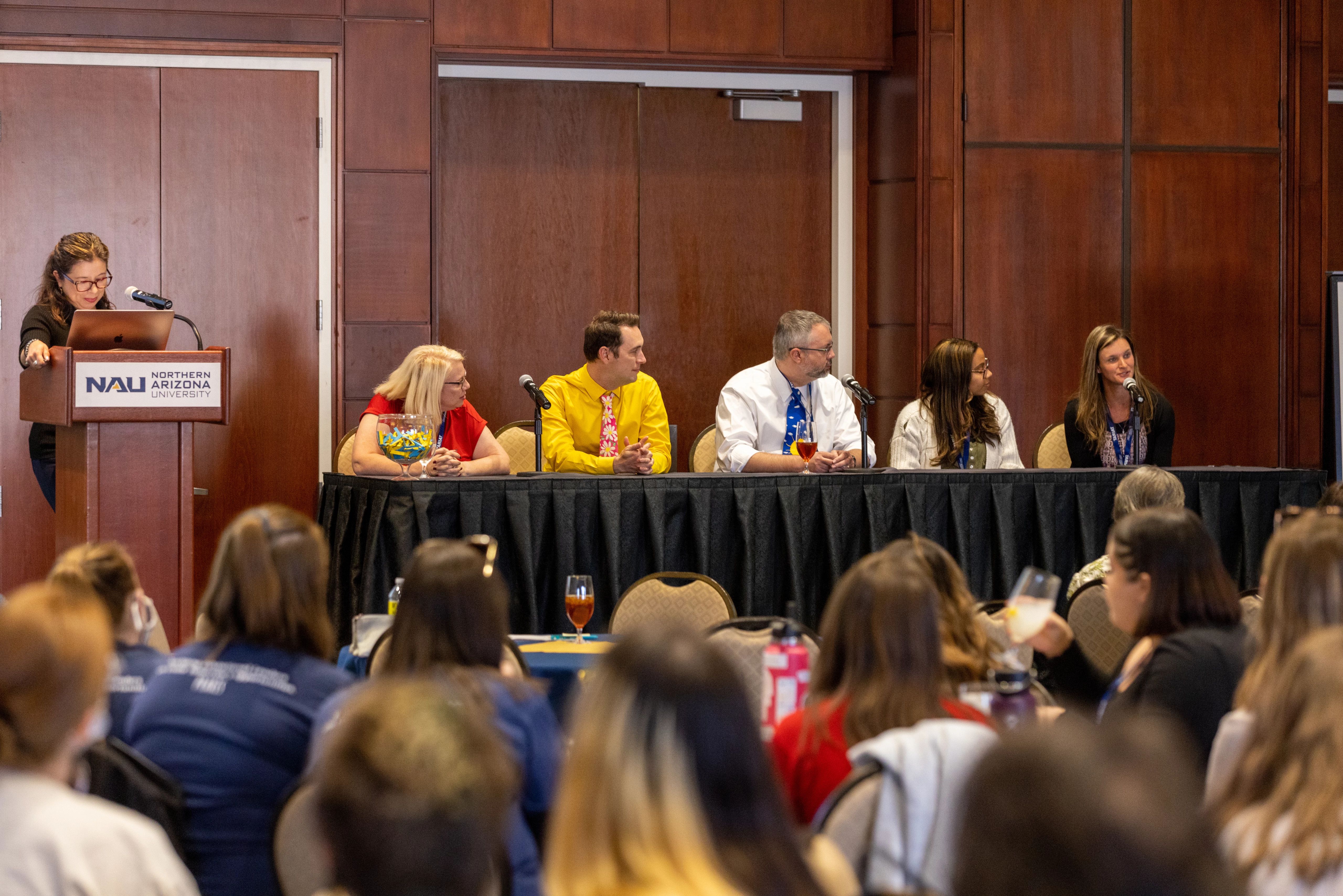 A panel of experts speaks to a crowd at N A U Tariat.
