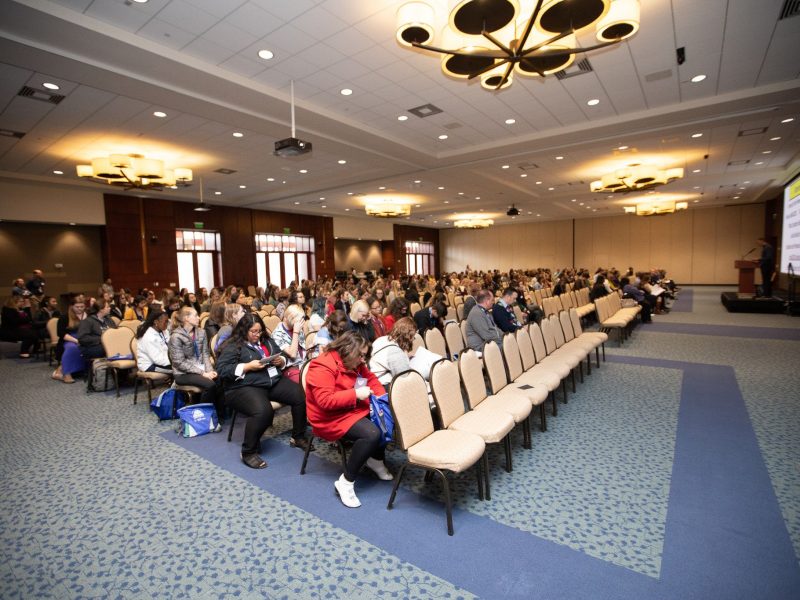 View of There's a Reason I am a Teacher conference, showing rows of seats and people waiting for the conference to begin.