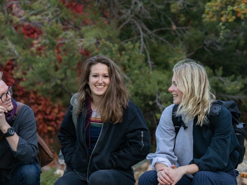 Students talking while sitting down outside.