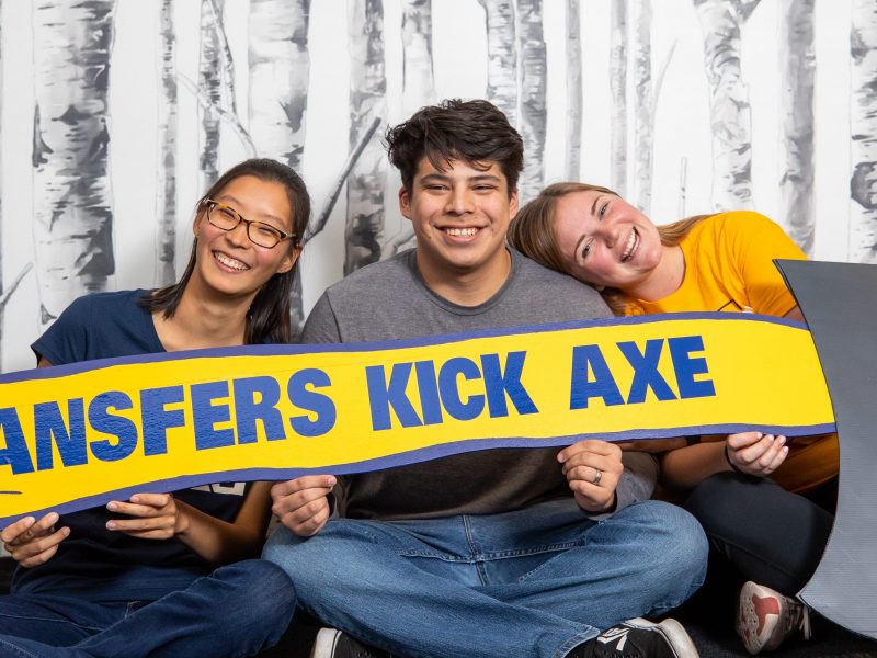 Students holding a larger N A U axe.