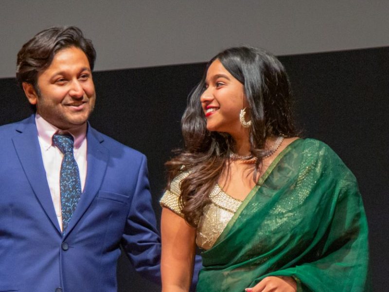 Students standing on stage smiling.