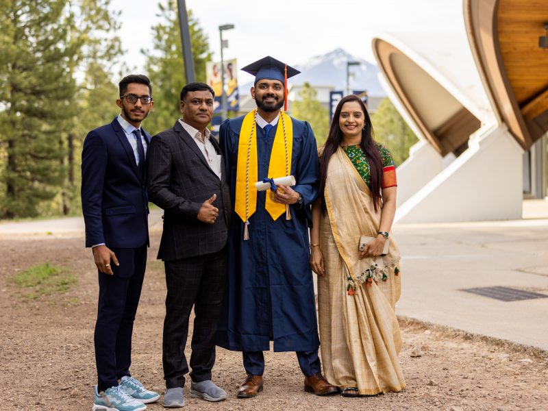 An NAU student at graduation ceremony with his family.