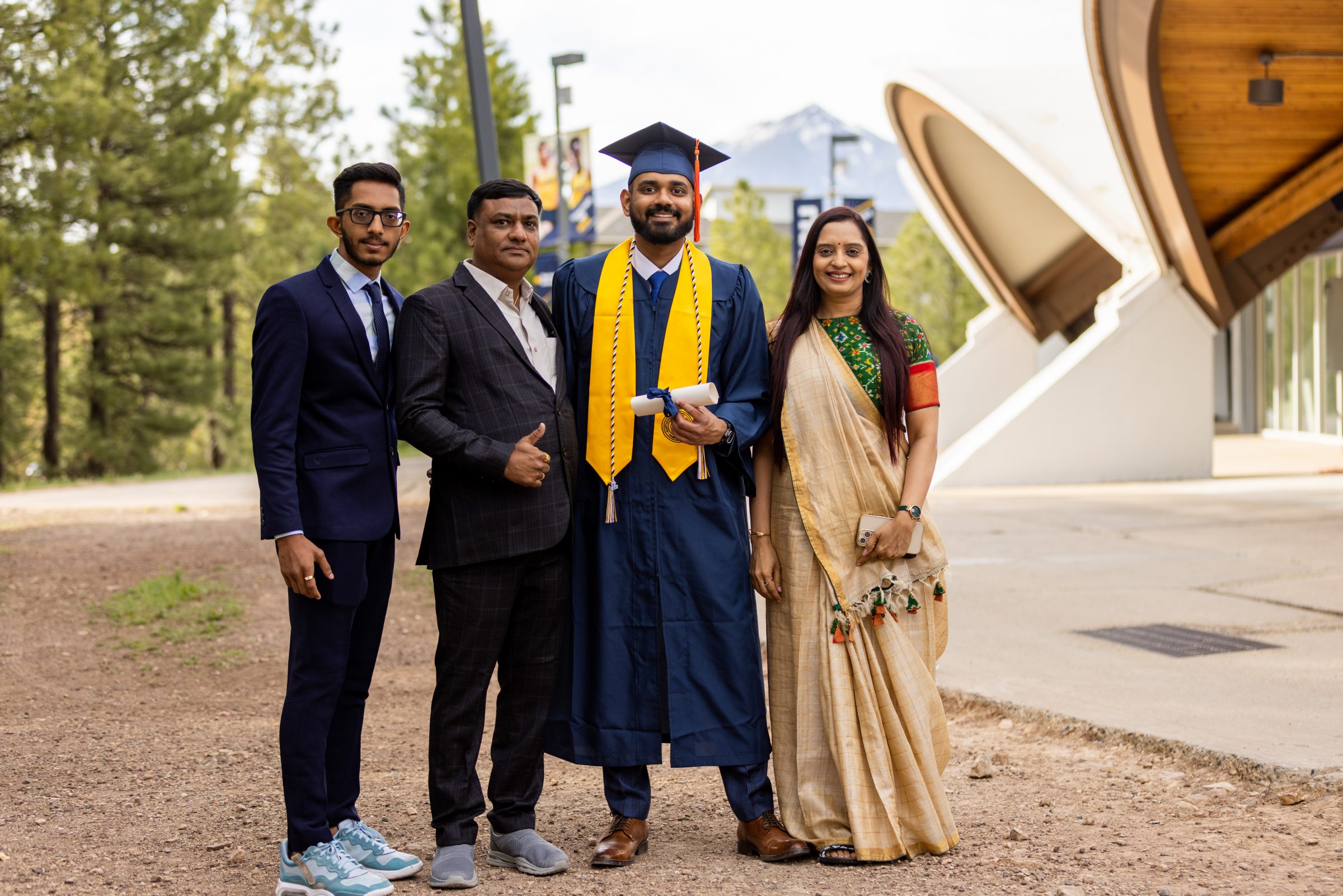 An NAU student at graduation ceremony with his family.