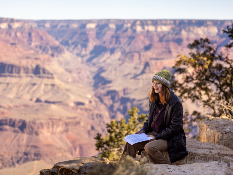 A women sitting on the grand canyon