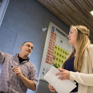 Instructor explains assignment to student in a classroom.