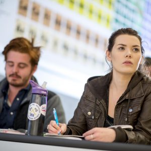 Students in science classroom take notes during lecture.