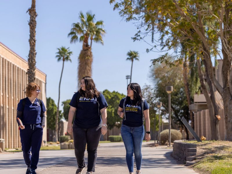 Three individuals walking on campus.
