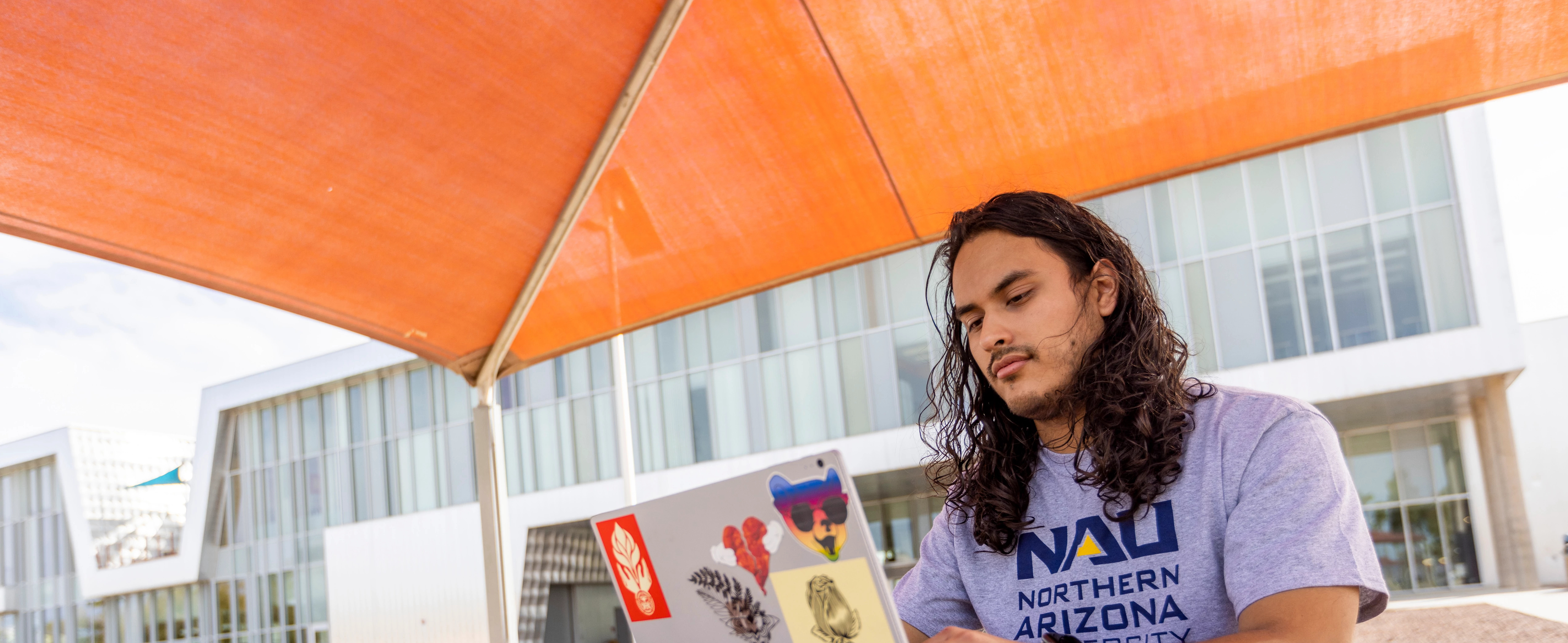 Student, Eduardo Moreno works outside at the N A U–Yuma campus.