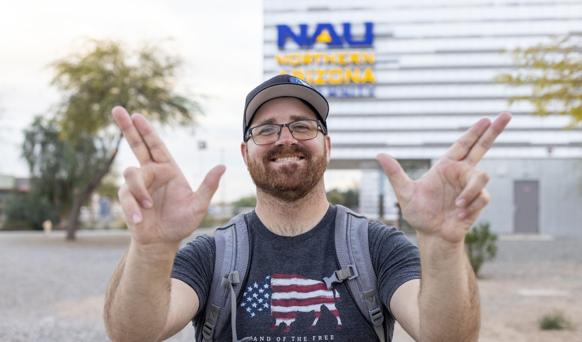N A U&ndash;Yuma student holding up hands in jack symbol.