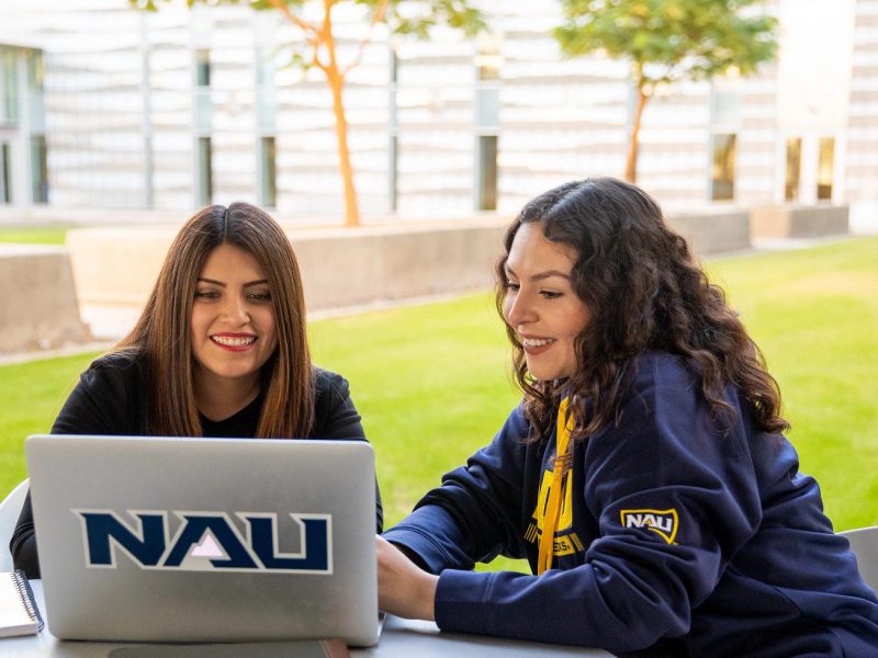 N A U&ndash;Yuma students outside working on Laptop.