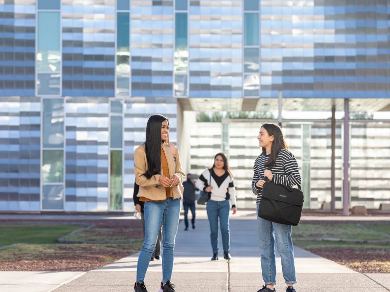 Students chatting outside of a building on the N A U&ndash;Yuma campus.