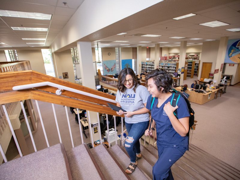 N A U&ndash;Yuma students walking in library.
