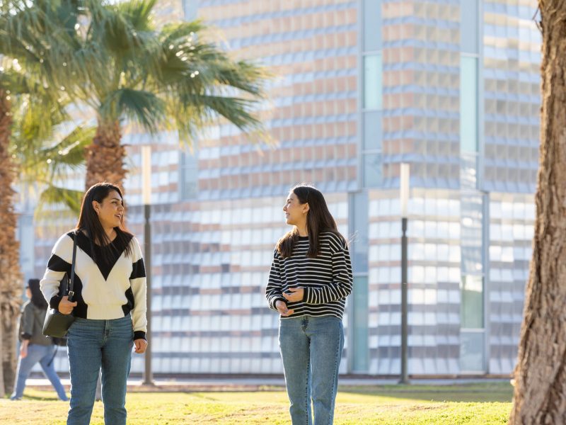 N A U&ndash;Yuma students talking outside on campus.
