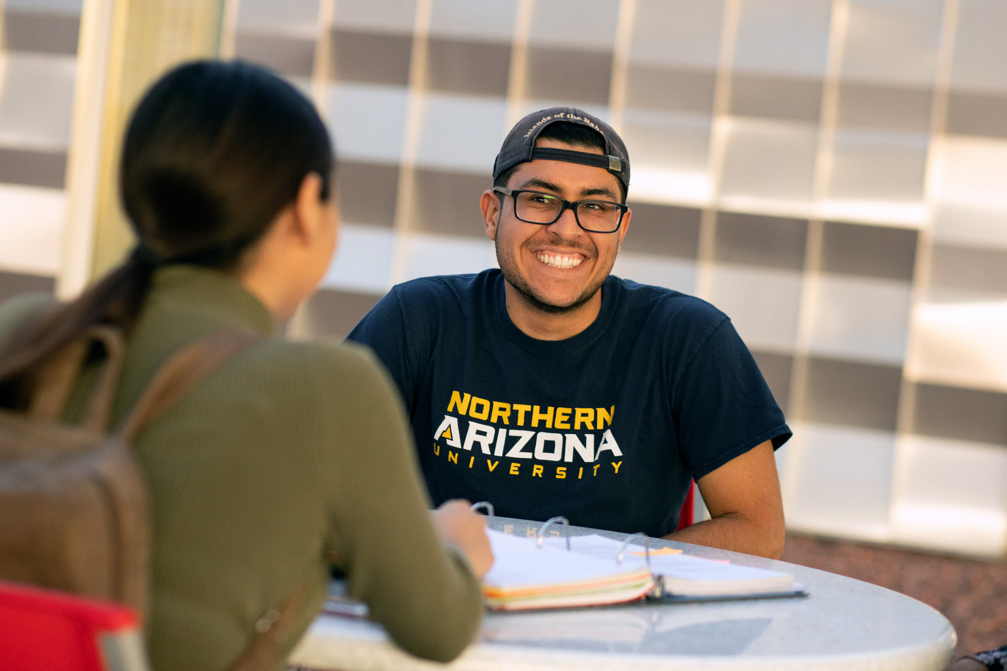 Two N A U&ndash;Yuma students sitting outside.