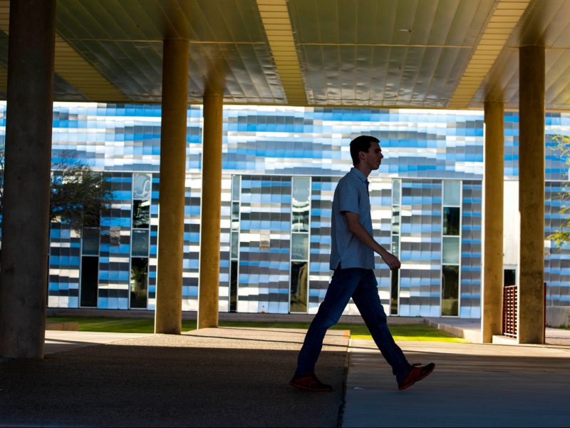 Person walking on N A U–Yuma campus.