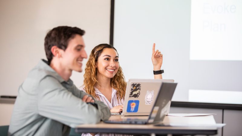 Students in classroom smiling.