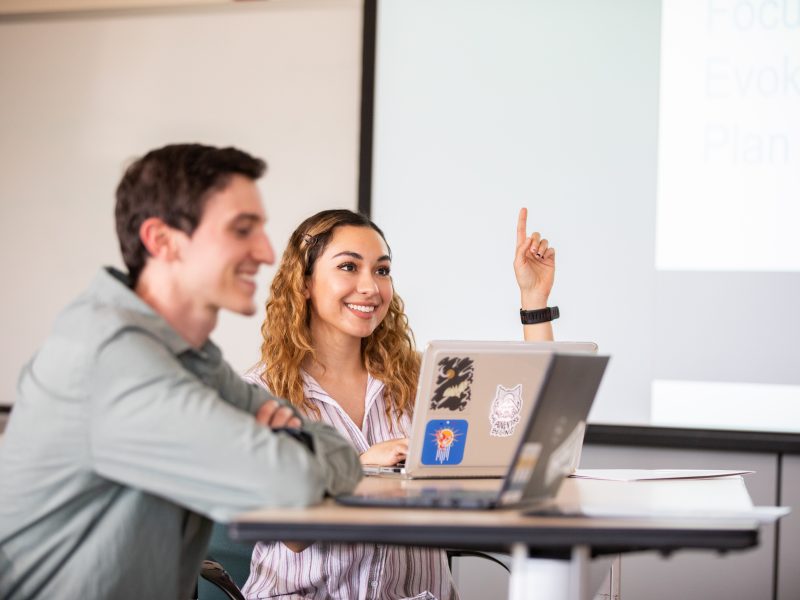 Students in classroom smiling.