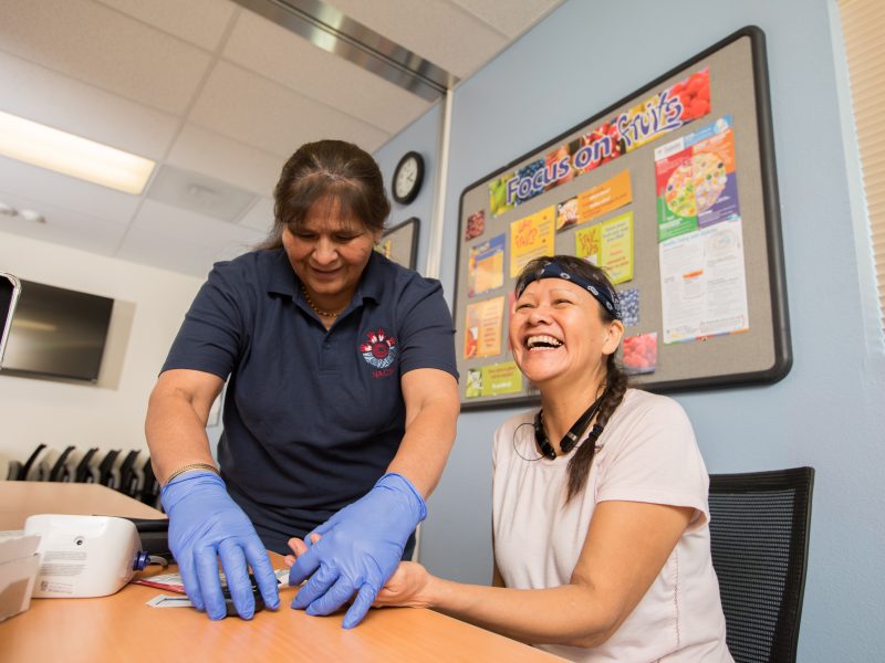 Students smiling while performing nurse practice.