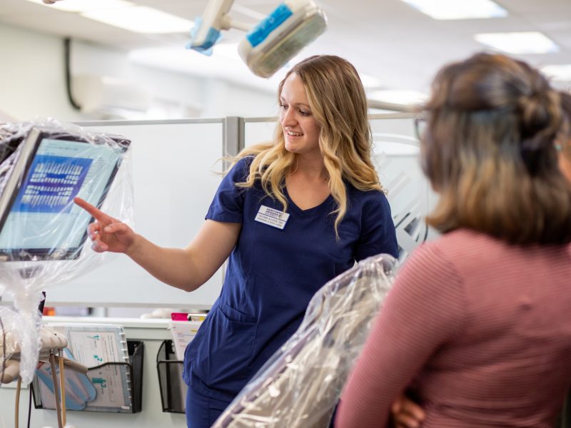 Student showing x-ray to patients.