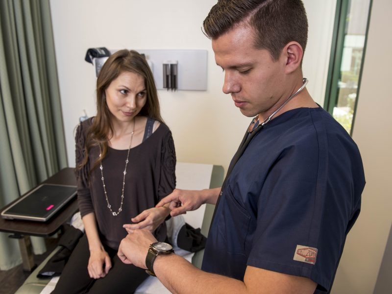 Student nursing assisting patient.