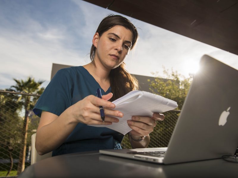 Student studying on her laptop while outdoors.