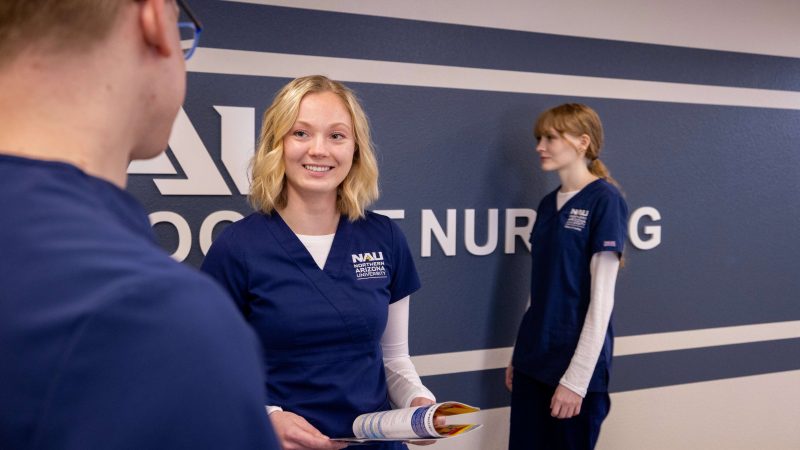 N A U Nursing students talk in the hallway between classes.