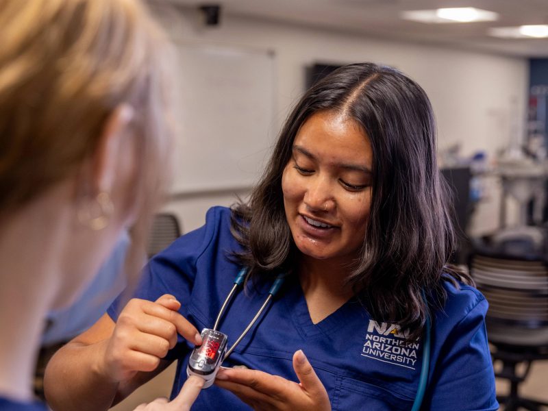A nursing student at N A U practices interacting with patients.