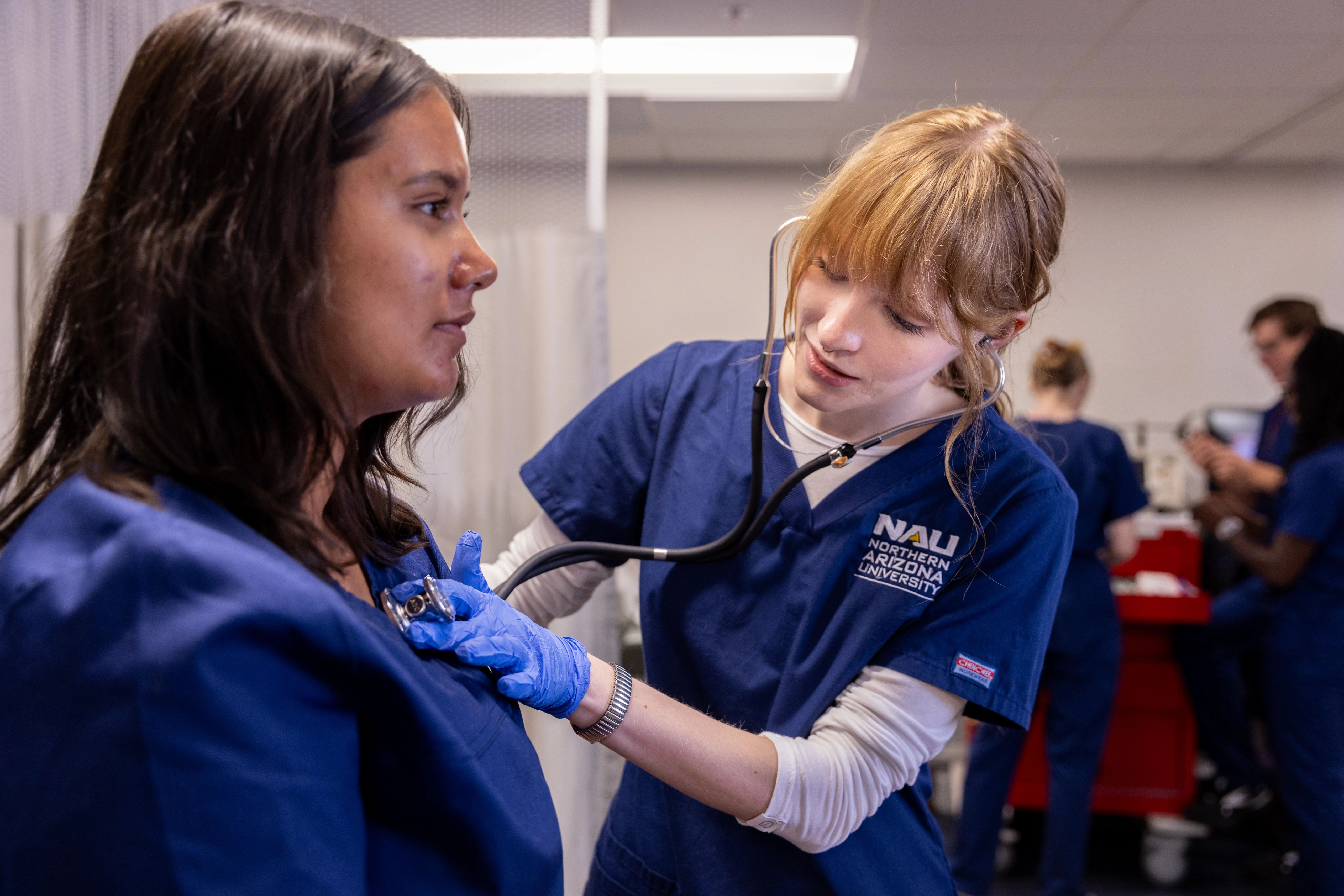 N A U Nursing students practice taking each other's vitals.