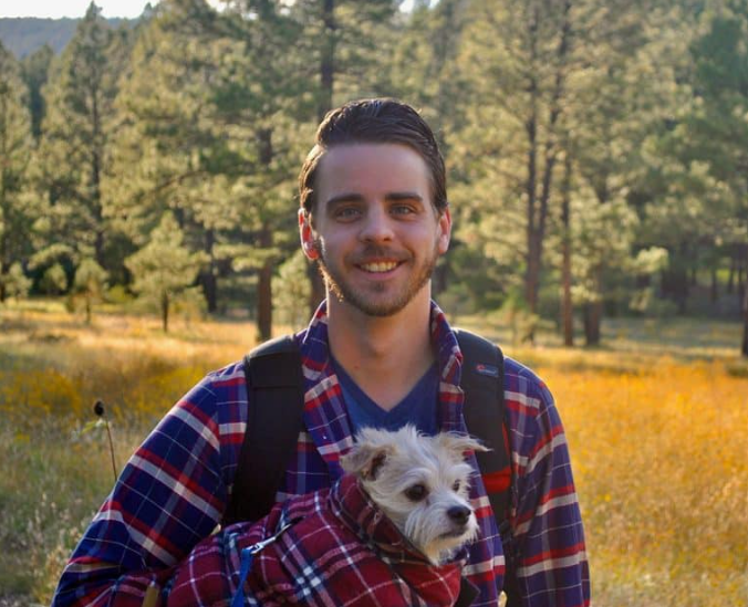 Cody Rieffer, an N A U College of Nursing student,posing with a dog in his arm