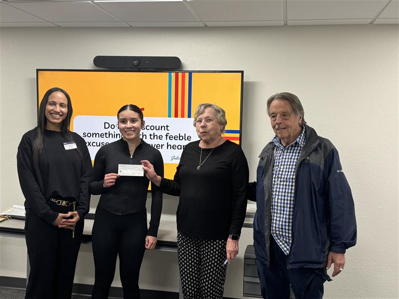 Two people presenting a check to two other people, the dean and a student.