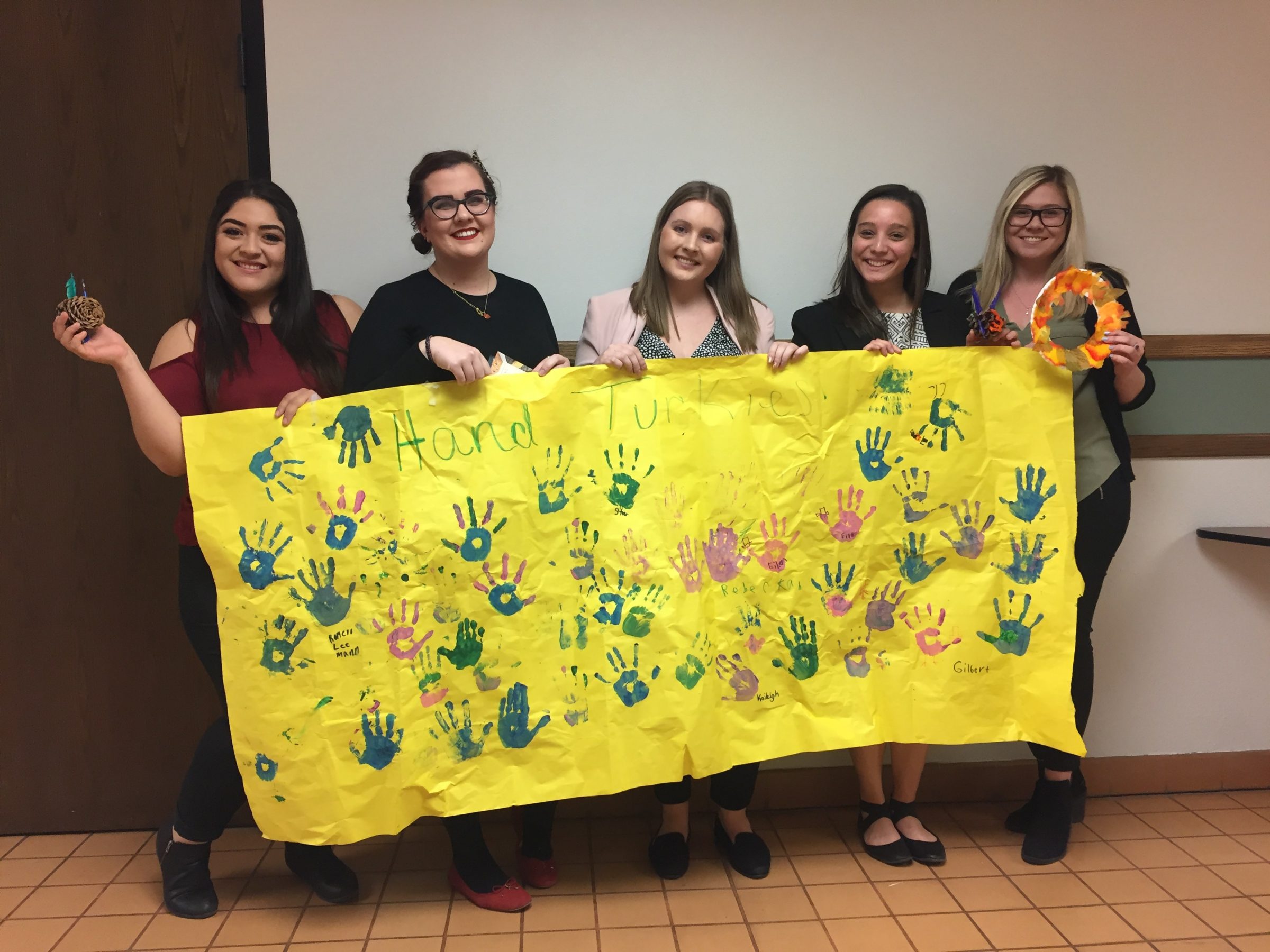 Social Work 423 students showing off creative projects made by elementary students at Killip Elementary Thanksgiving Carnival.