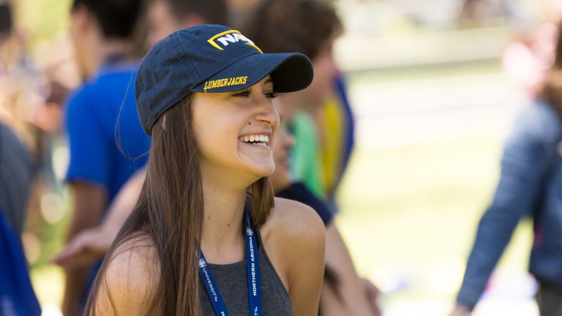 A photo of a new student smiling and wearing N A U gear.