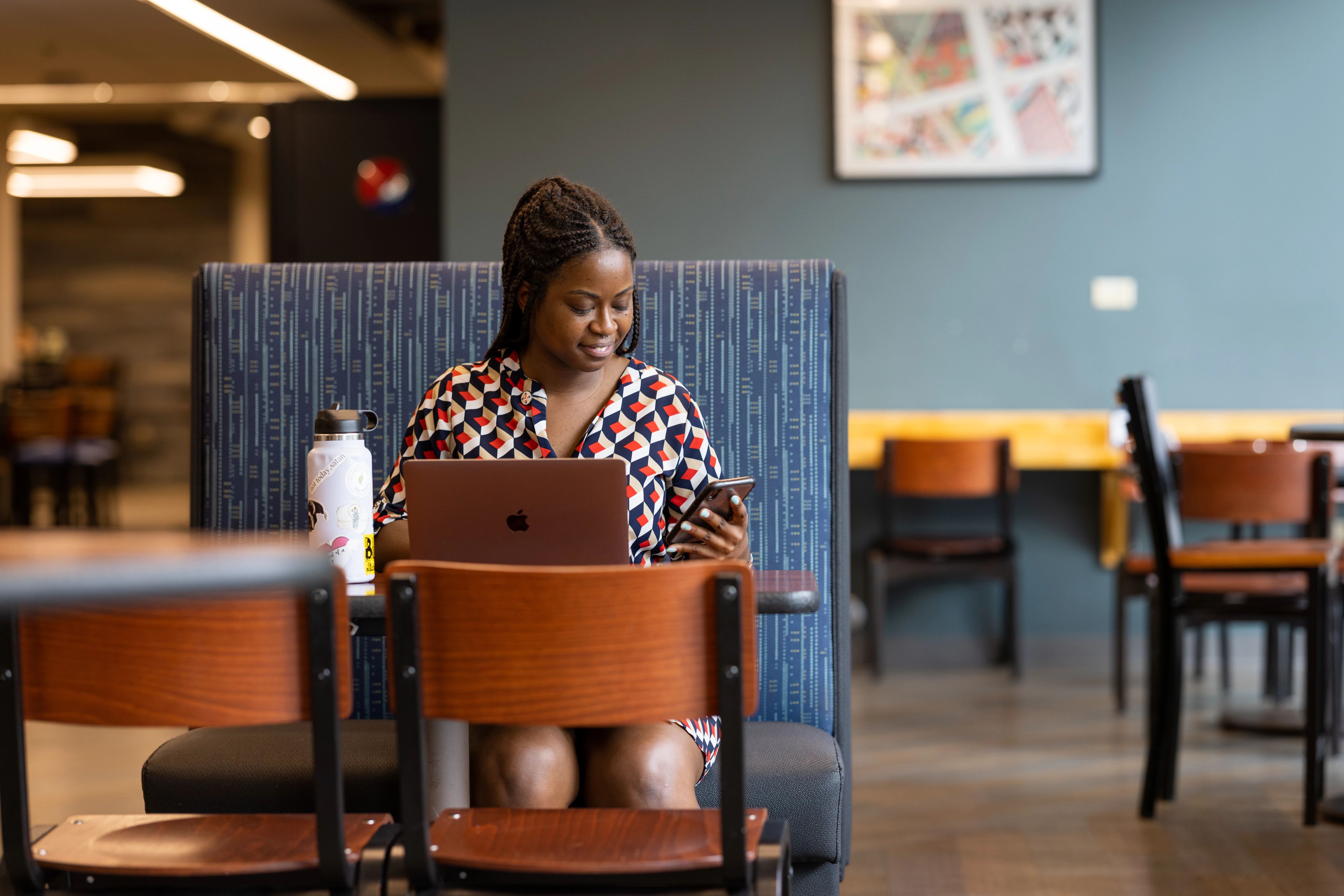 Student sitting at a campus eatery working on a computer.