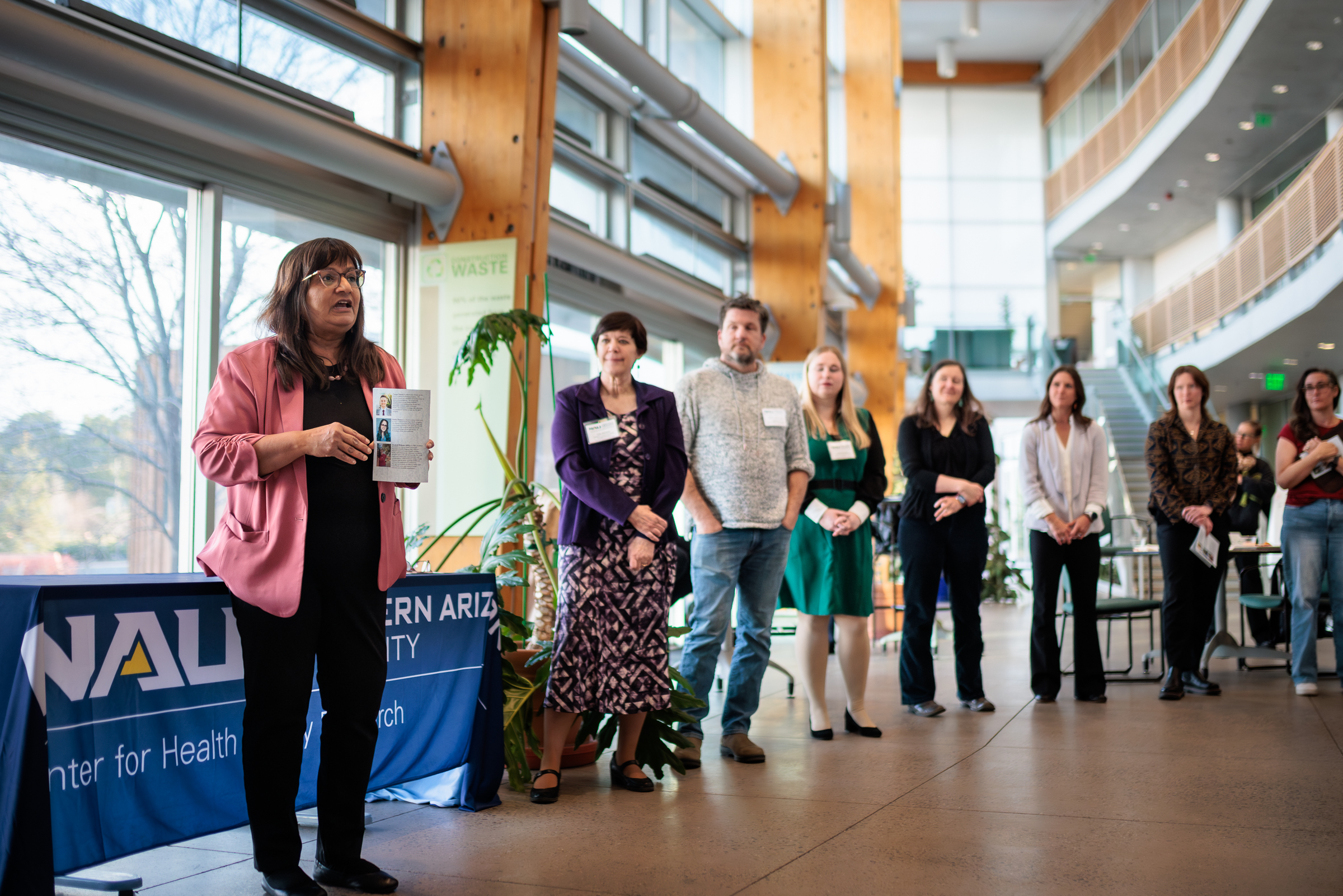 A professor addresses the group from a podium to present certificates to the graduates.